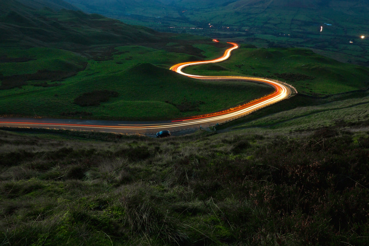 aerial view of road between green grass field