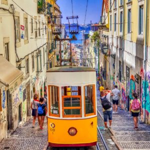 People walking on street near yellow tram