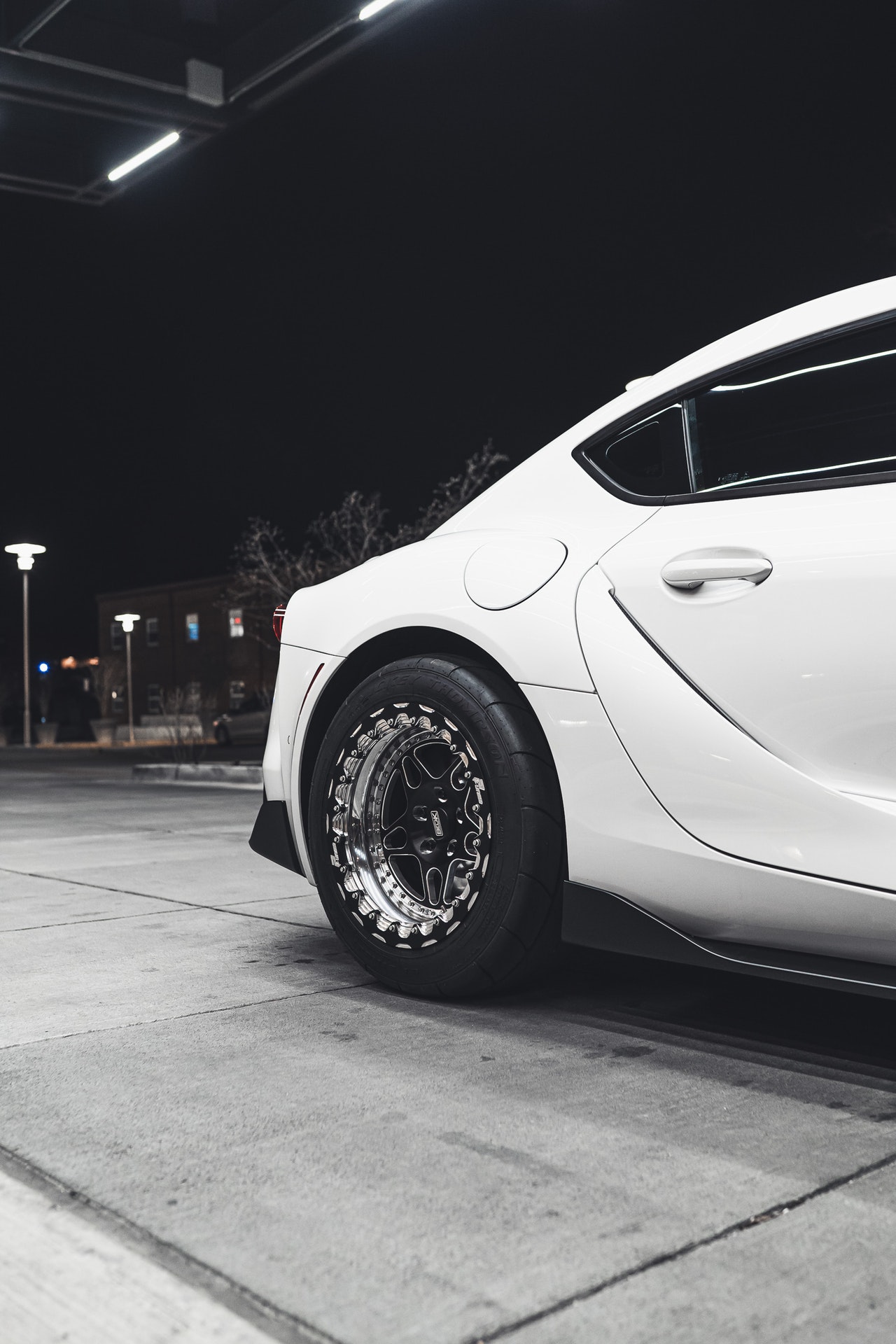 White car on gray concrete road during night time